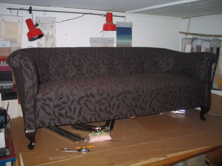 Tummalla kankaalla verhoiltu sohva